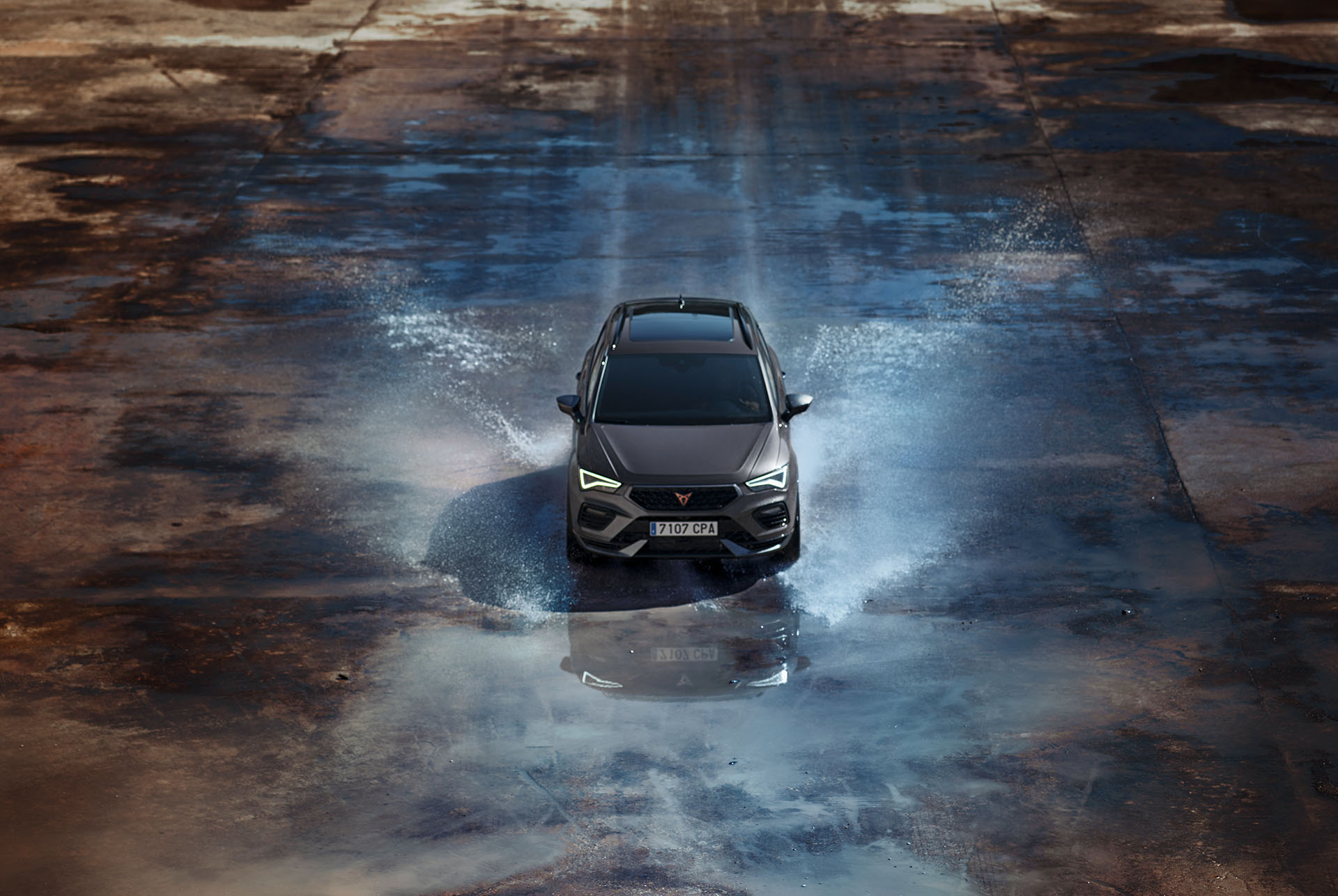 Vista frontal del CUPRA Ateca circulando por el agua, mostrando su capó destacado, los faros Full LED, los detalles en aluminio oscuro y los frenos de alto rendimiento con pinzas Brembo. 