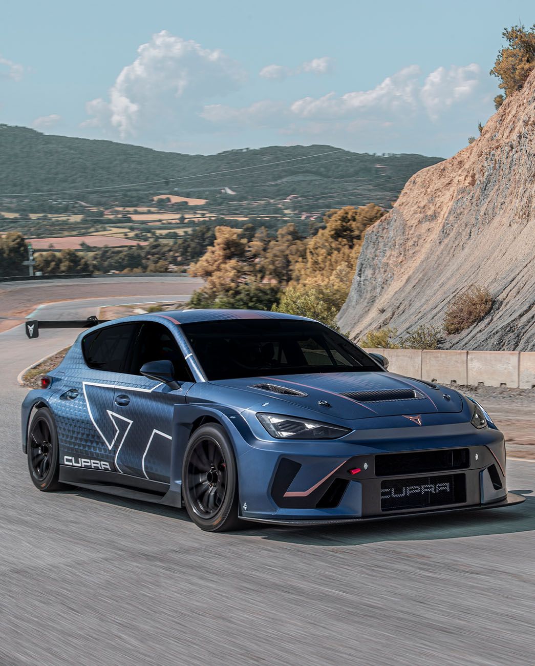 El CUPRA León VZ TCR circulando por una carretera de montaña donde se observa su aerodinámica mejorada.