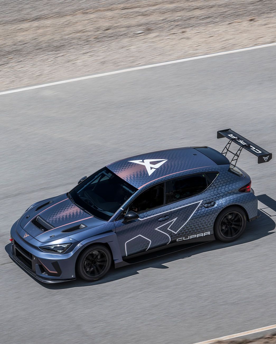 El CUPRA León VZ TCR circulando por una carretera de montaña donde se observa su aerodinámica mejorada.