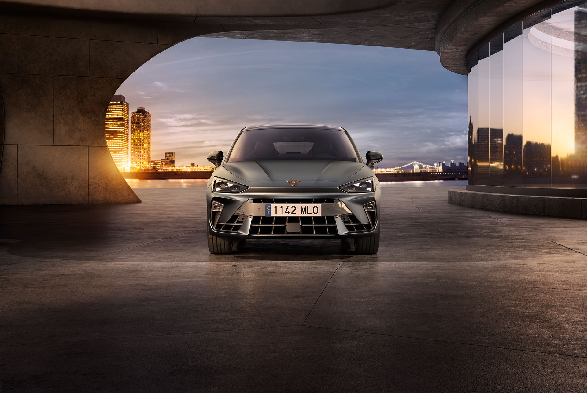 Nuevas versiones de modelos y equipamientos del coche CUPRA León 2024, entradas de aire, faros con forma de ojo triangular, puesta de sol, cristales, arquitectura y cielo azul.