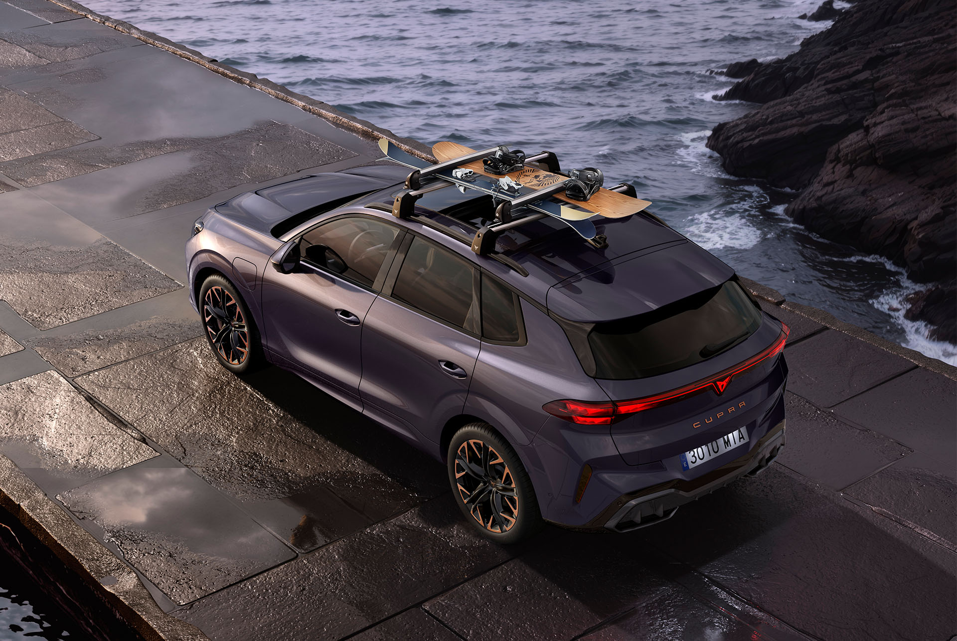 CUPRA Terramar with ski rack carrying skis. The SUV is parked on a coastal road, preparing for a winter adventure, showcasing the vehicle's versatility and the easy-to-install ski rack system.