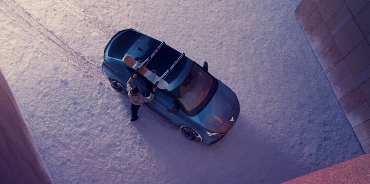 Person with a surfboard  preparing to load it onto a cupra formentor, obtained with an operating lease.